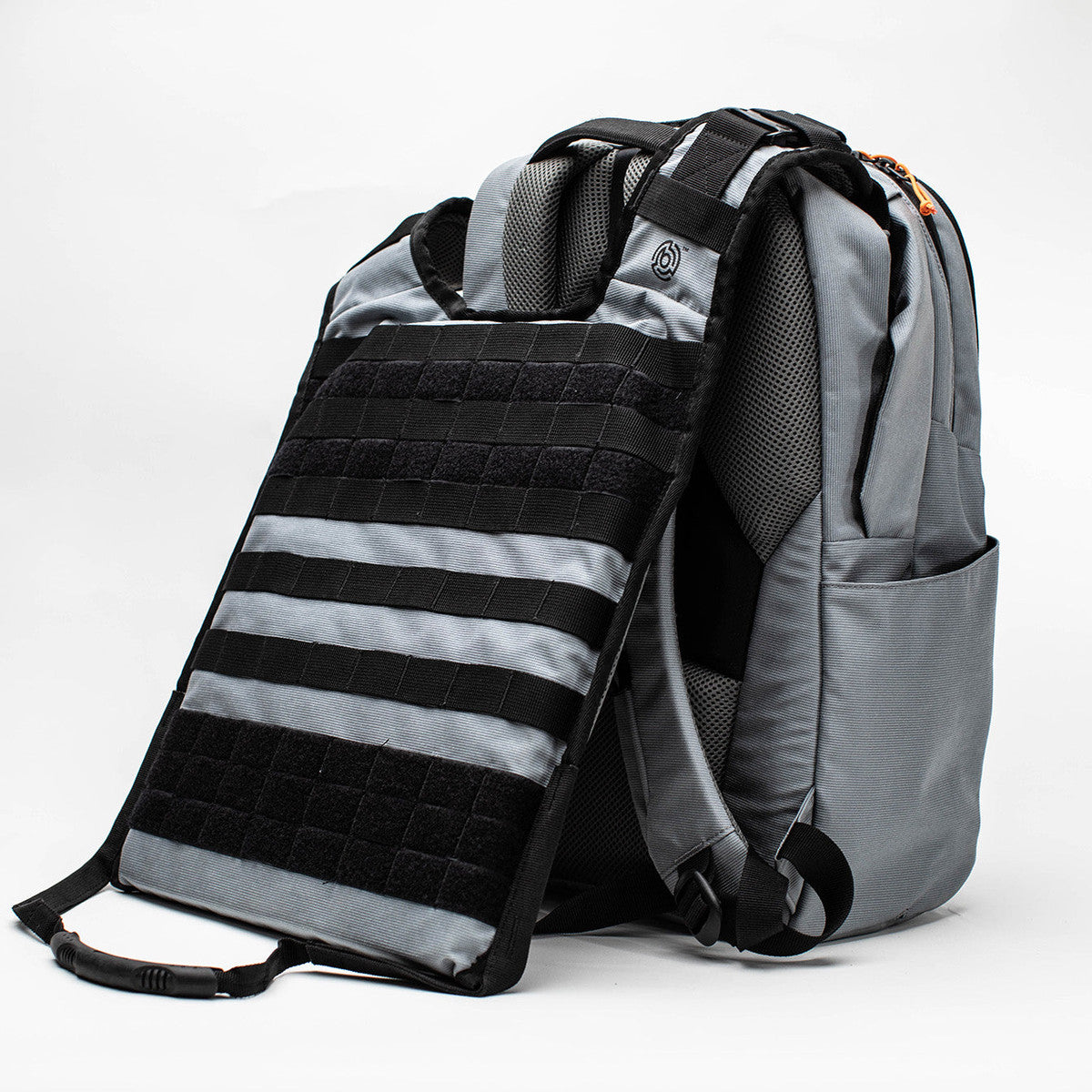 A gray and black tactical-style backpack shown on a white studio background, with a detachable black and gray body armor clipped onto the front.